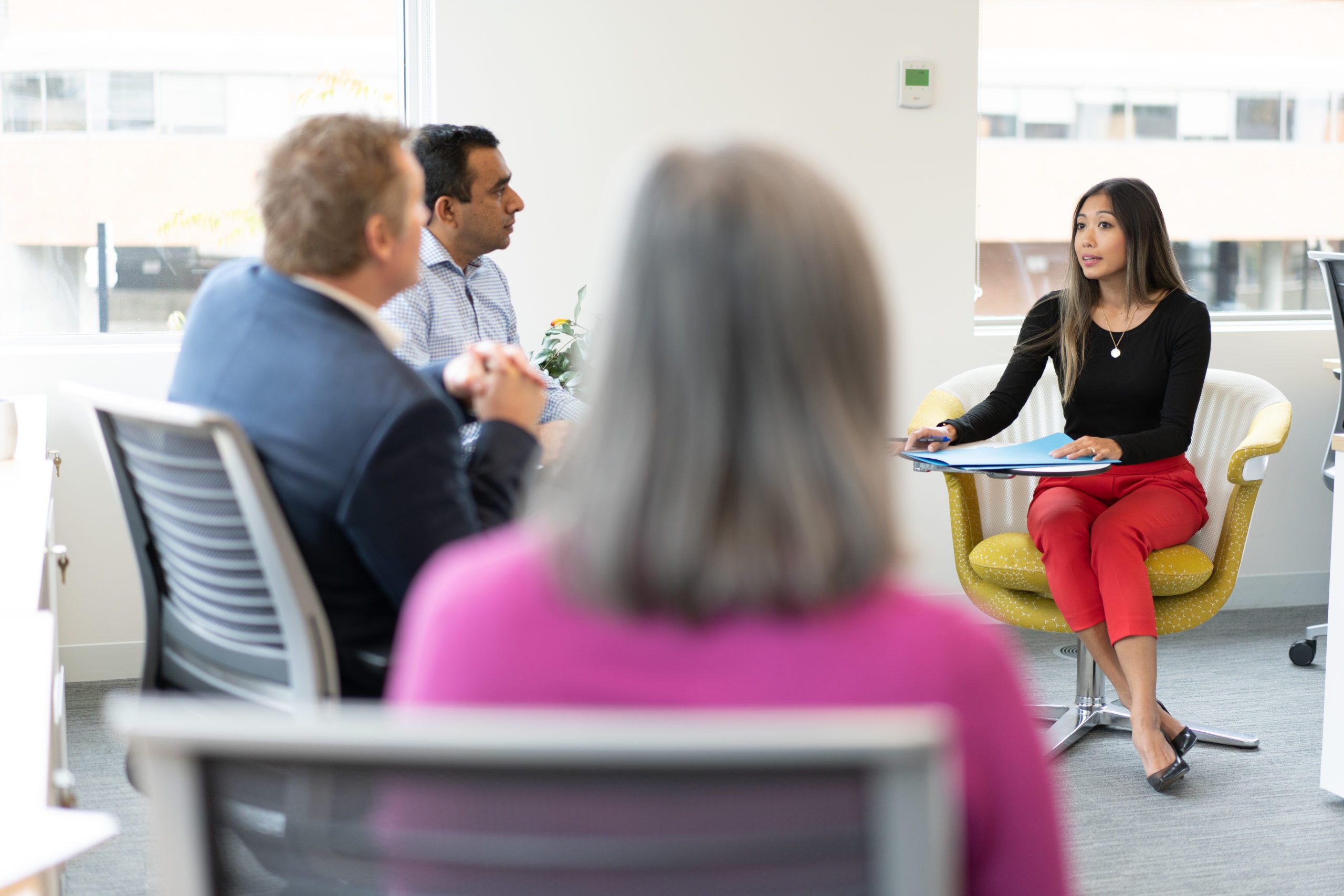 Three BCI employees sitting in a relaxed workspace, facing another employee who is making a presentation. Three BCI employees sitting in a relaxed workspace, facing another employee who is making a presentation.